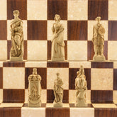 A handmade chess set depicting figures from the Battle of Culloden, with pieces in ivory and burgundy colours, placed on a checkered background.