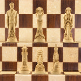 The ivory coloured side of a nautical-themed chess set with pieces including a Captain, Mermaid, Navigator, Seahorse, Lighthouse, and Ship, displayed on a brown and beige chess board.