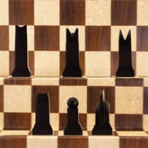 A handmade chess set with pieces in black and white, displayed on a checkered board. The set includes various shapes of pieces, such as rooks, knights, bishops, and pawns, showcasing an Art Deco design style.