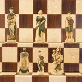 A hand-painted chess set featuring historical figures, with pieces arranged on a checkered background.