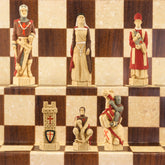 Hand painted chess pieces with a Crusades theme, including figures like King Richard the Lionheart and Saladin, displayed on a chess board.
The chess set concentrates particularly on the Third great Crusade led by King Richard I of England, who in 1189 joined King Philip II of France in an effort to recapture the holy city of Jerusalem. King Richard, with 8000 troops, seized Cyprus and some cities on the Palestinian coast, but ultimately failed to dislodge the Muslim leader Saladin from Jerusalem.