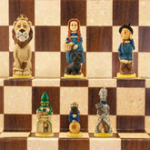Hand-painted chess pieces featuring characters from 'The Wonderful Wizard of Oz', placed on a chess board.