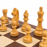 Wooden chess pieces on a chessboard with a white background
