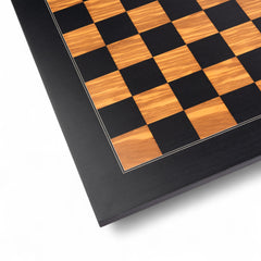 Close-up of a chessboard with black and wooden checkered pattern on a white background