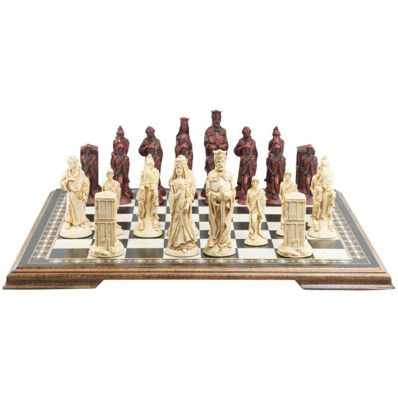 A handpainted chess set featuring characters from the Arthurian legend, placed on a checkered board. The set includes figures representing King Arthur, Queen Guinevere, Merlin the Magician, Sir Lancelot the Knight, & the Castle of Camelot as the rook.