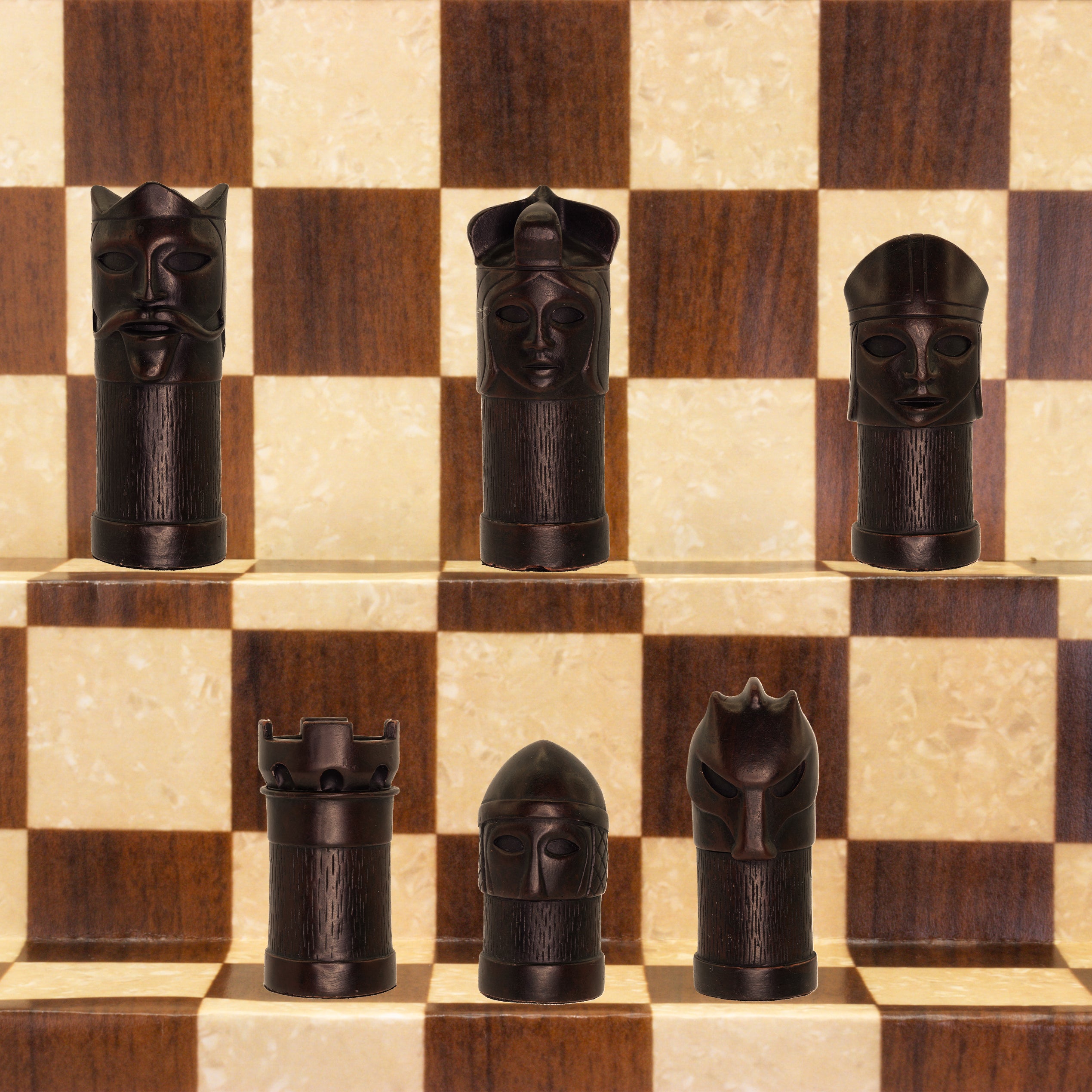 The black coloured side of a hand made chess set inspired by a fusion of traditional staunton chess piece design and medieval masquerades.