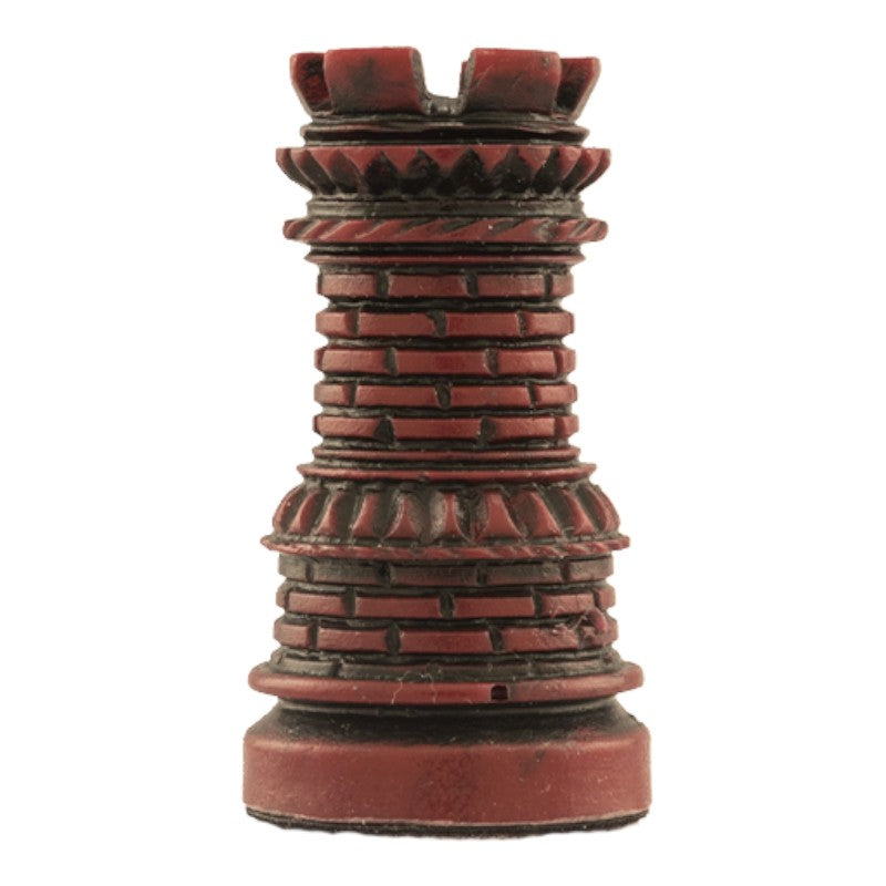 A hand made burgundy coloured chess piece depicting a Castle tower, with architecture that was typical in a western european court in the Middle Ages.