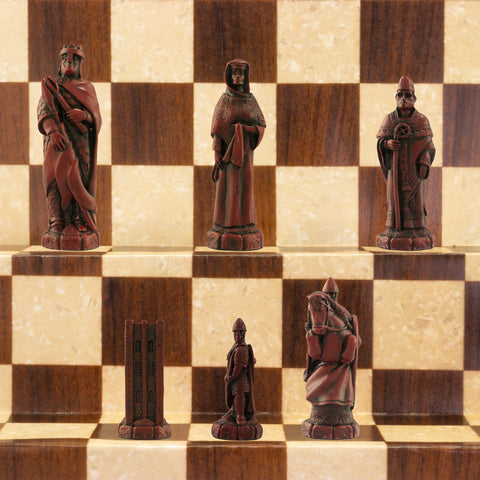 A handmade chess set depicting characters from the Battle of Hastings, with pieces representing King Harold II of England, Edith Swan-Neck, Archbishop Stigand, William the Conqueror, and other Saxon and Norman figures, placed on a checkered background.