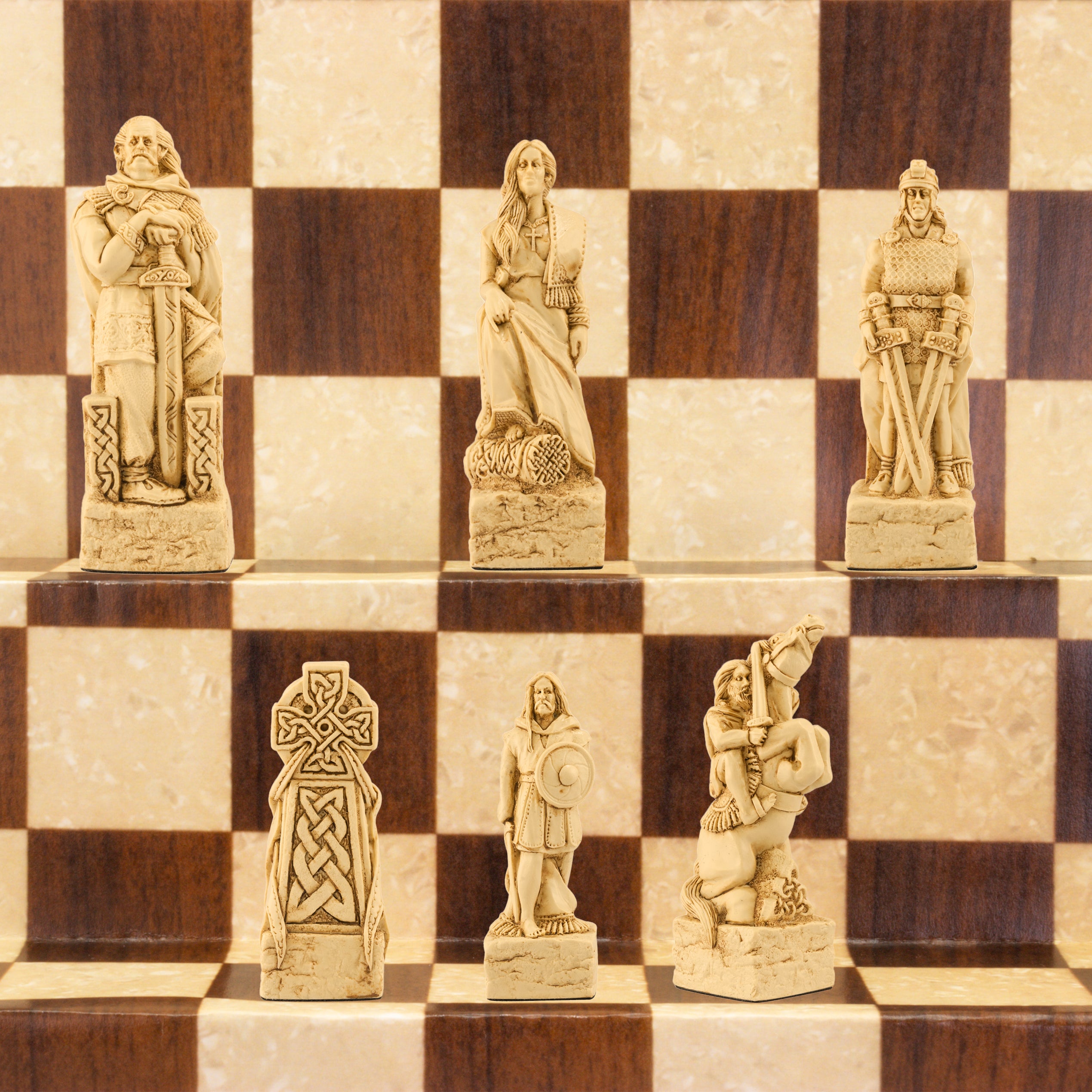 A close-up of a handmade chess set with pieces designed in Celtic styles, set up on a wooden chess board.