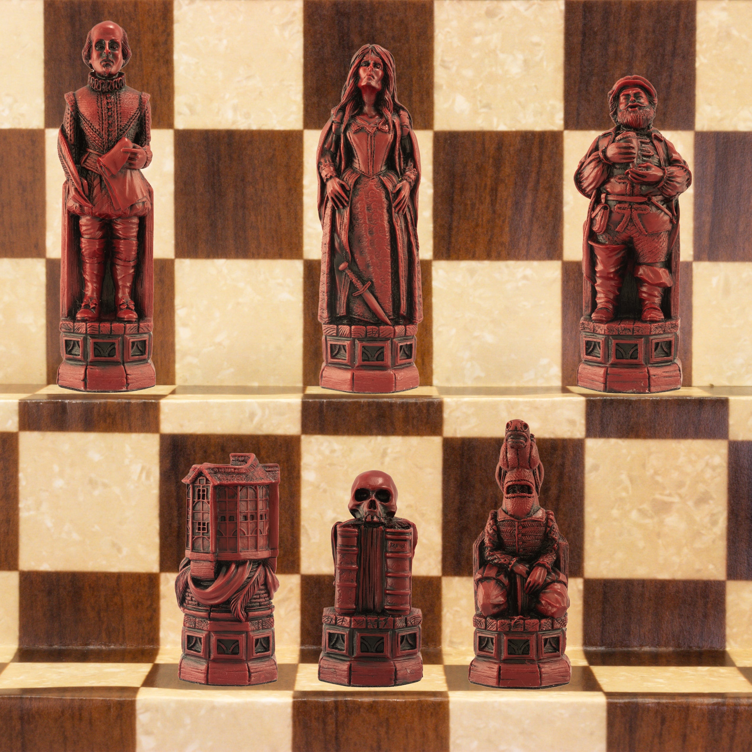The burgundy coloured side of a handmade chess set depicting Shakespeare, Lady Macbeth, Sir John Fallstaff, Nick bottom & The Globe theatre displayed on a wooden chess board.