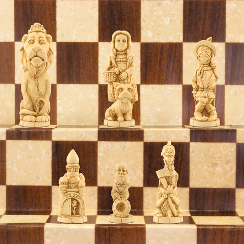 A handmade chess set featuring characters from 'The Wonderful Wizard of Oz' by L. Frank Baum, placed on a wooden chess board.