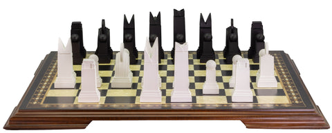 A handmade chess set with pieces in black and white, displayed on a checkered board. The set includes various shapes of pieces, such as rooks, knights, bishops, and pawns, showcasing an Art Deco design style.