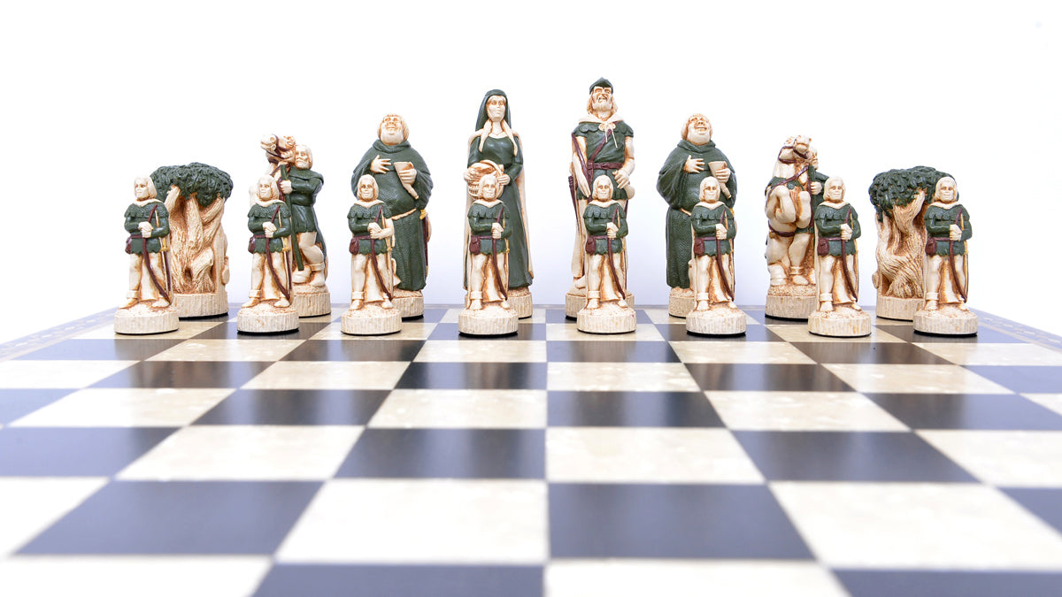 One side of a hand painted themed chess set, inspired by the legend surrounding Robin Hood. This side contains Robin Hood as the King, Maid Marian as the Queen, Friar Tuck as the Bishop, Will Scarlet as the Knight, A Sherwood Tree as the Rook & The Merry Men as the Pawn pieces.
These pieces are displayed atop a black and white wooden chessboard.