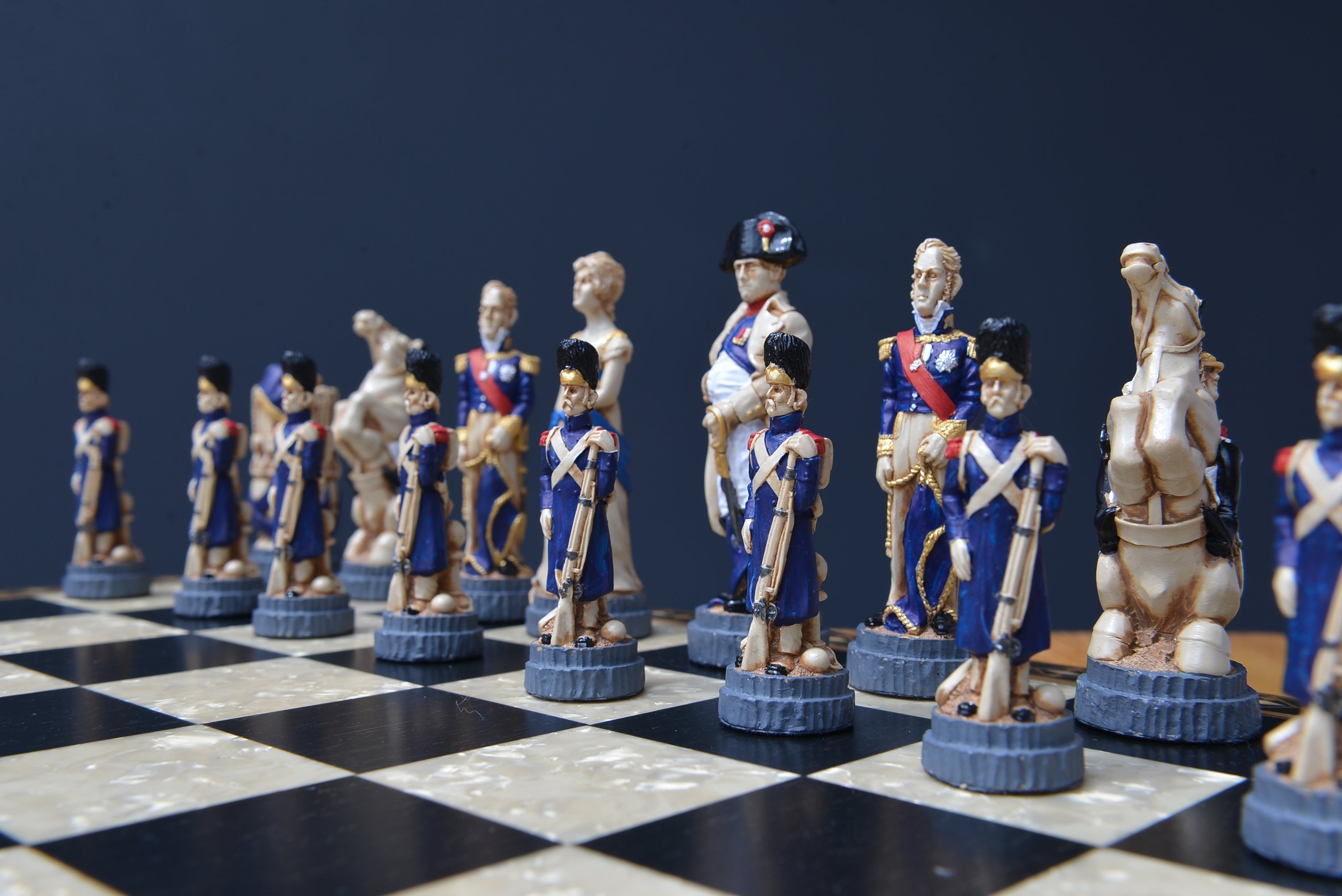 A hand made chess set depicting characters from the Battle of Waterloo, placed on a chess board in a lifestyle shot.
