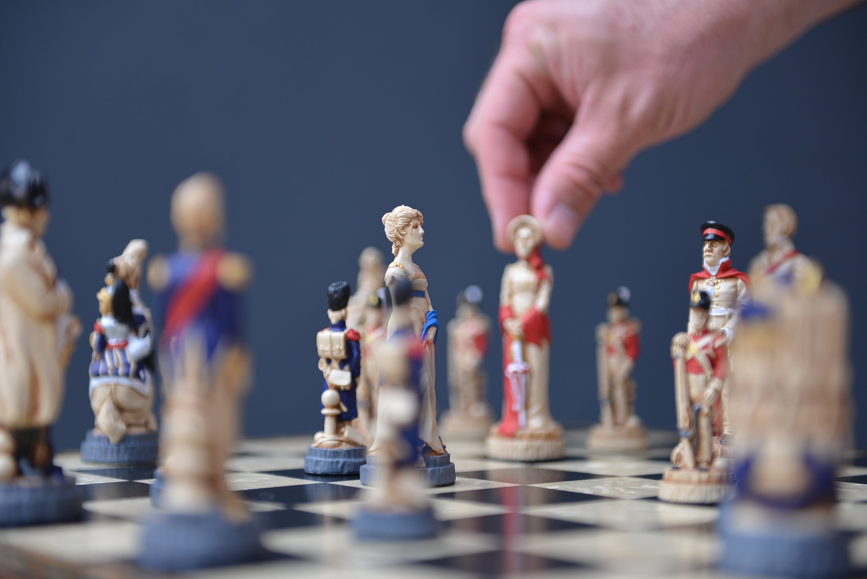 A hand made chess set depicting characters from the Battle of Waterloo, placed on a chess board in a lifestyle shot.