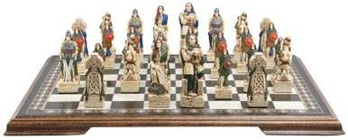 A handmade chess set with pieces designed in Celtic styles, set up on a wooden chess board.