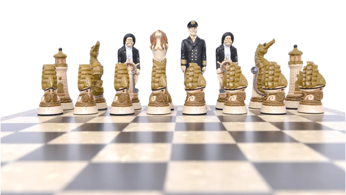 The cream base, gold accented side of a nautical-themed hand painted chess set with pieces including a Captain, Mermaid, Navigator, Seahorse, Lighthouse, and Ship, displayed on a black and white chess board.