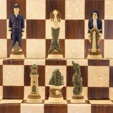 The cream base, green accented side of a nautical-themed hand painted chess set with pieces including a Captain, Mermaid, Navigator, Seahorse, Lighthouse, and Ship, displayed on a brown and beige chess board.