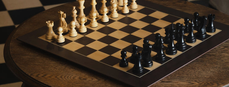 Chessboard with black and white pieces on a wooden table