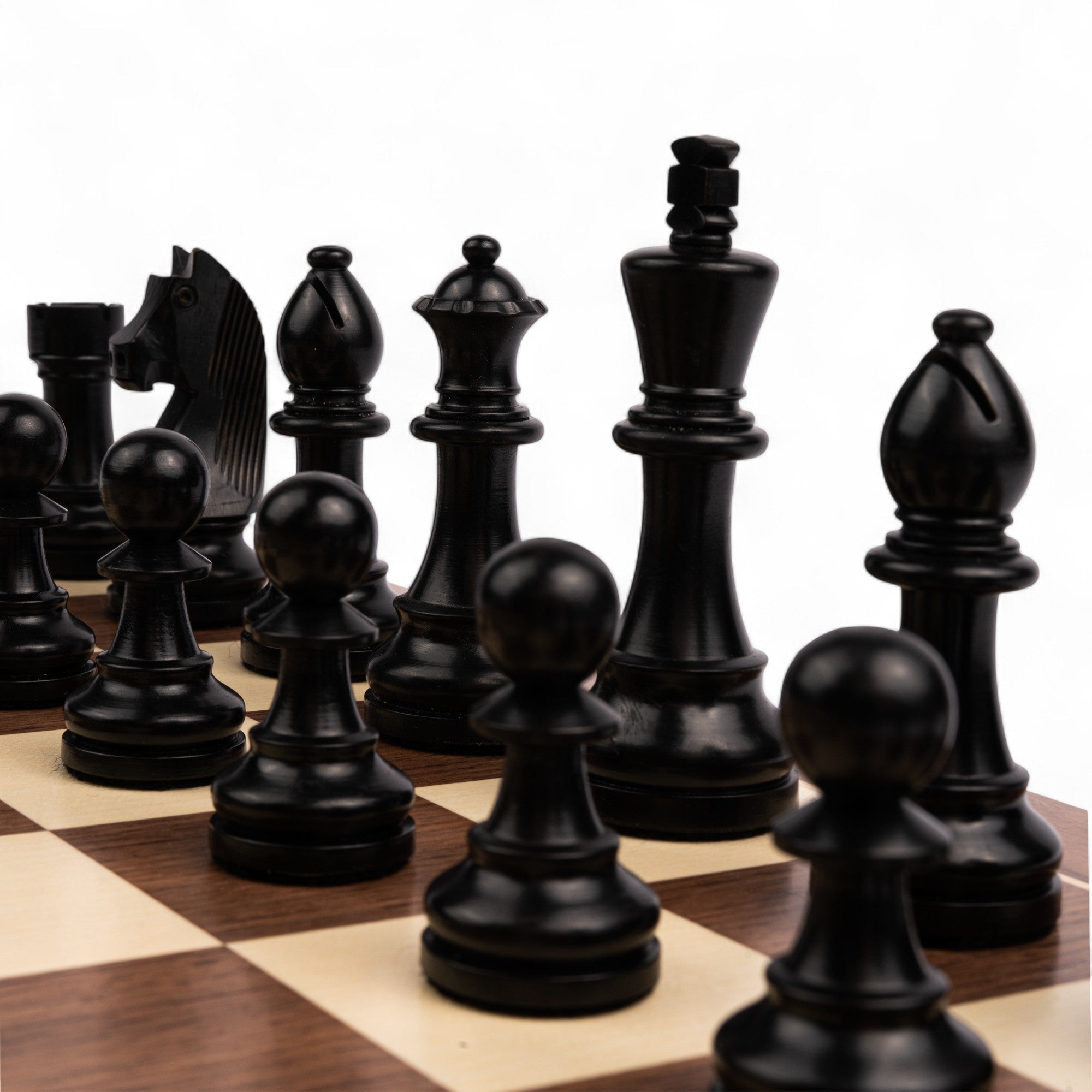 Black chess pieces on a wooden chessboard