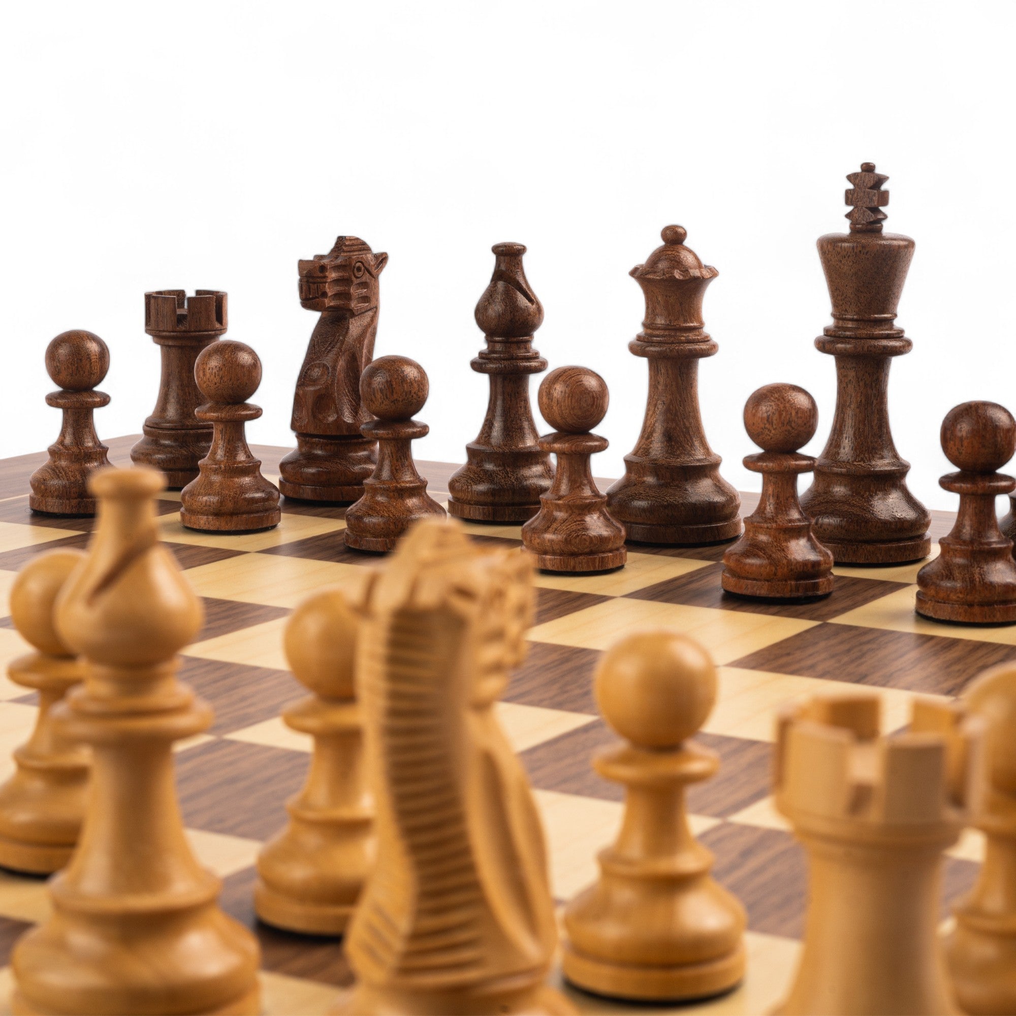 Wooden chess pieces on a chessboard with a white background